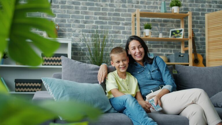 Mãe e filho sentados juntos no sofá da sala